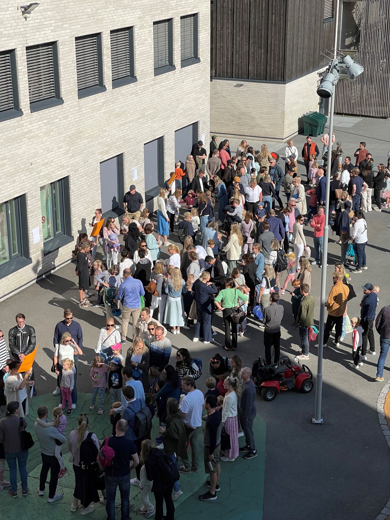 En stor gruppe mennesker samlet seg utenfor en bygning En stor gruppe mennesker samlet seg utenfor en bygning