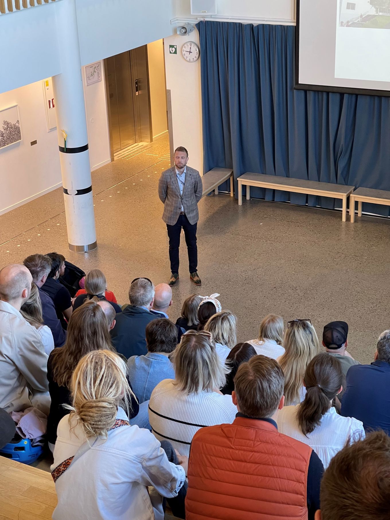 en person som står foran en gruppe mennesker en person som står foran en gruppe mennesker