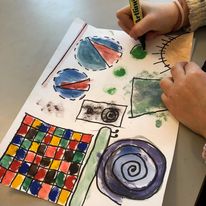 en person som tegner på et stykke papir