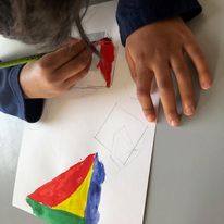 en person som tegner på et stykke papir