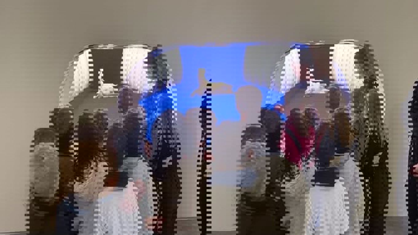 en gruppe mennesker som ser på en hund i en blå tunnel