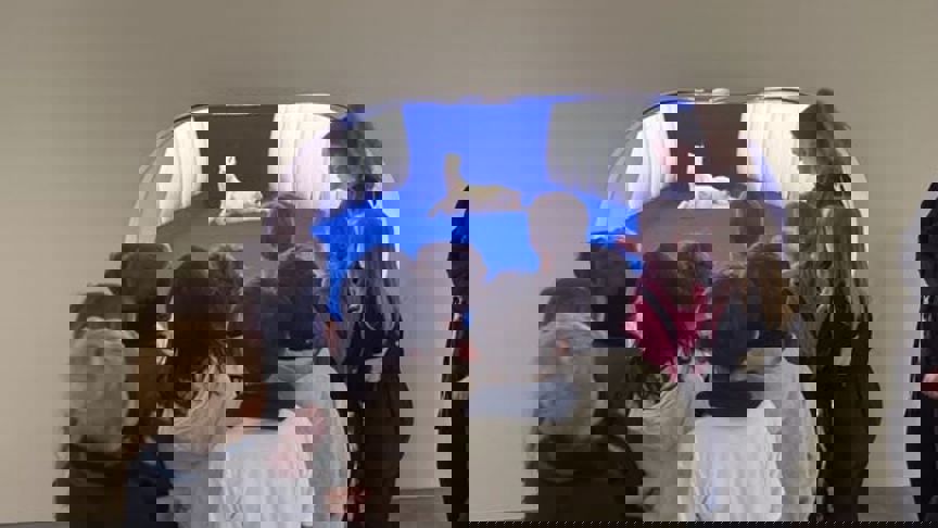 en gruppe mennesker som ser på en hund i en blå tunnel en gruppe mennesker som ser på en hund i en blå tunnel