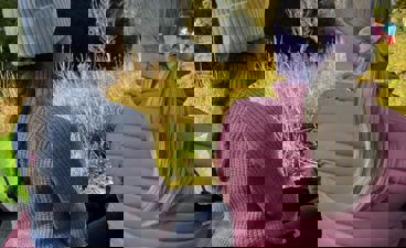 en gruppe barnr som sitter på en benk og ser på et jorde