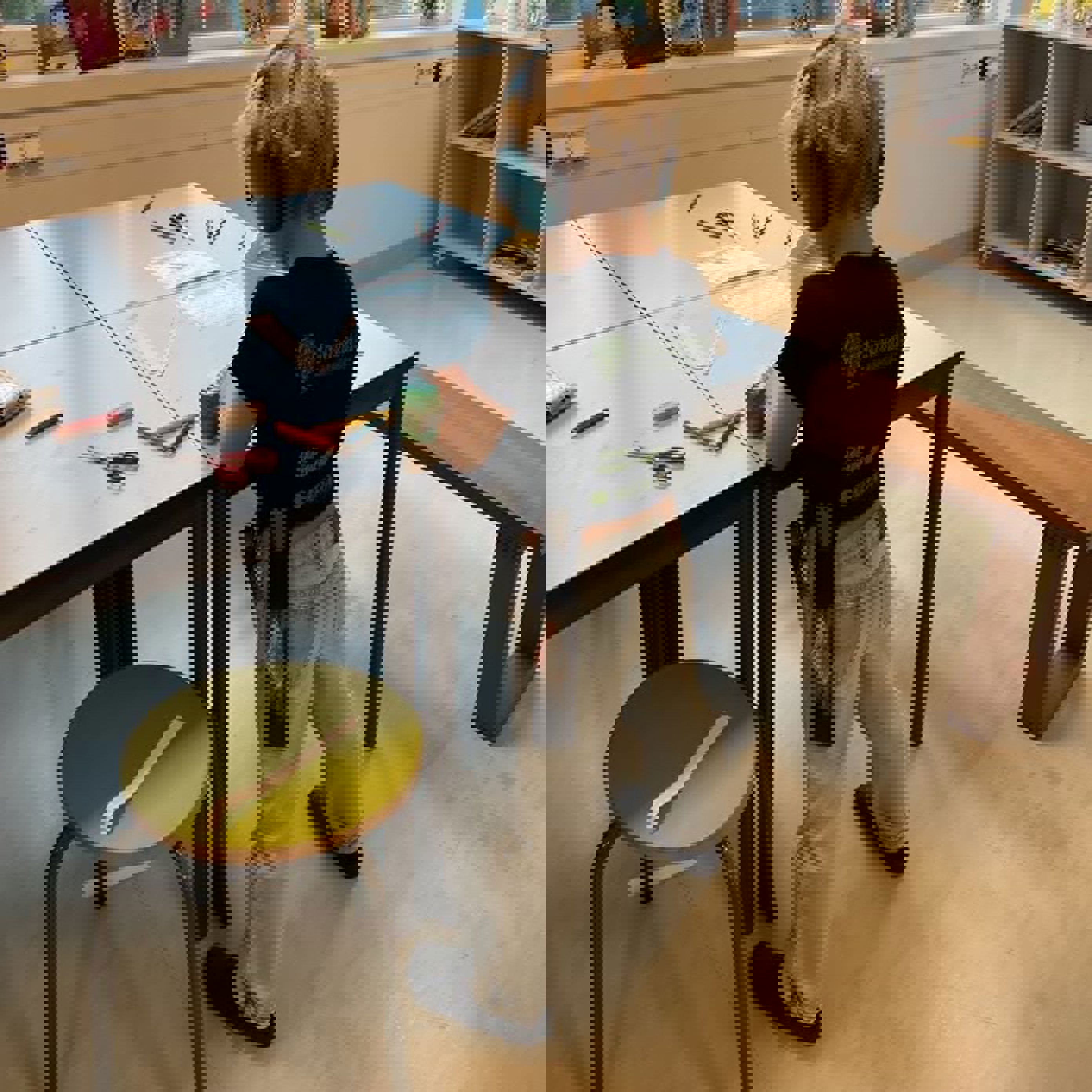 et barn som står foran et skrivebord med en stol og en bok et barn som står foran et skrivebord med en stol og en bok