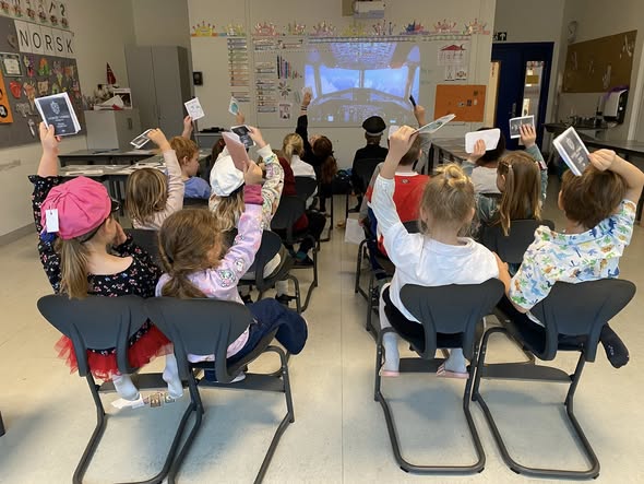 en gruppe barn som sitter i et klasserom