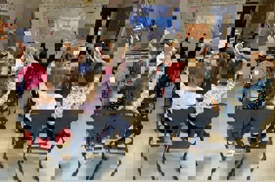 en gruppe barn som sitter i et klasserom