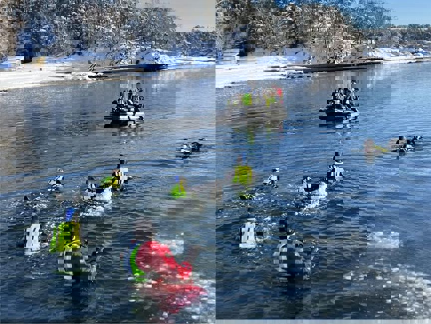 En gruppe mennesker i kajakker i en innsjø