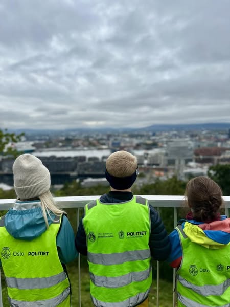 En gruppe mennesker iført sikkerhetsvester som ser på en by