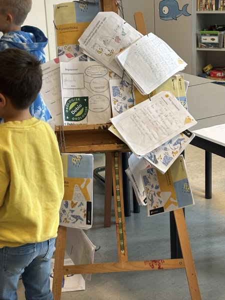 et barn som ser på en bok på et bord