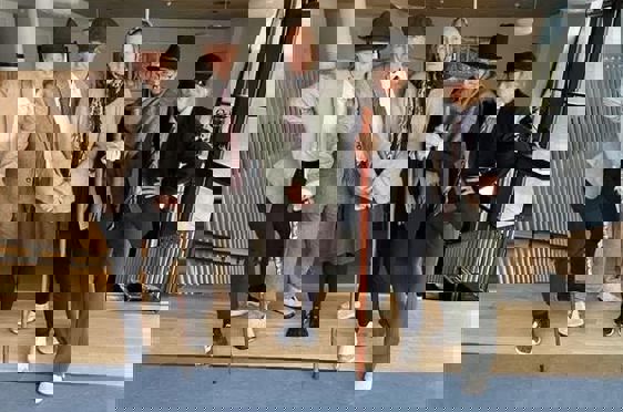 en gruppe mennesker i dresser som holder sverd