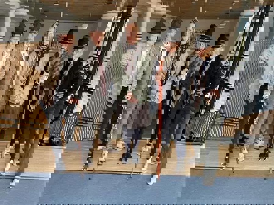 en gruppe mennesker i dresser som holder sverd