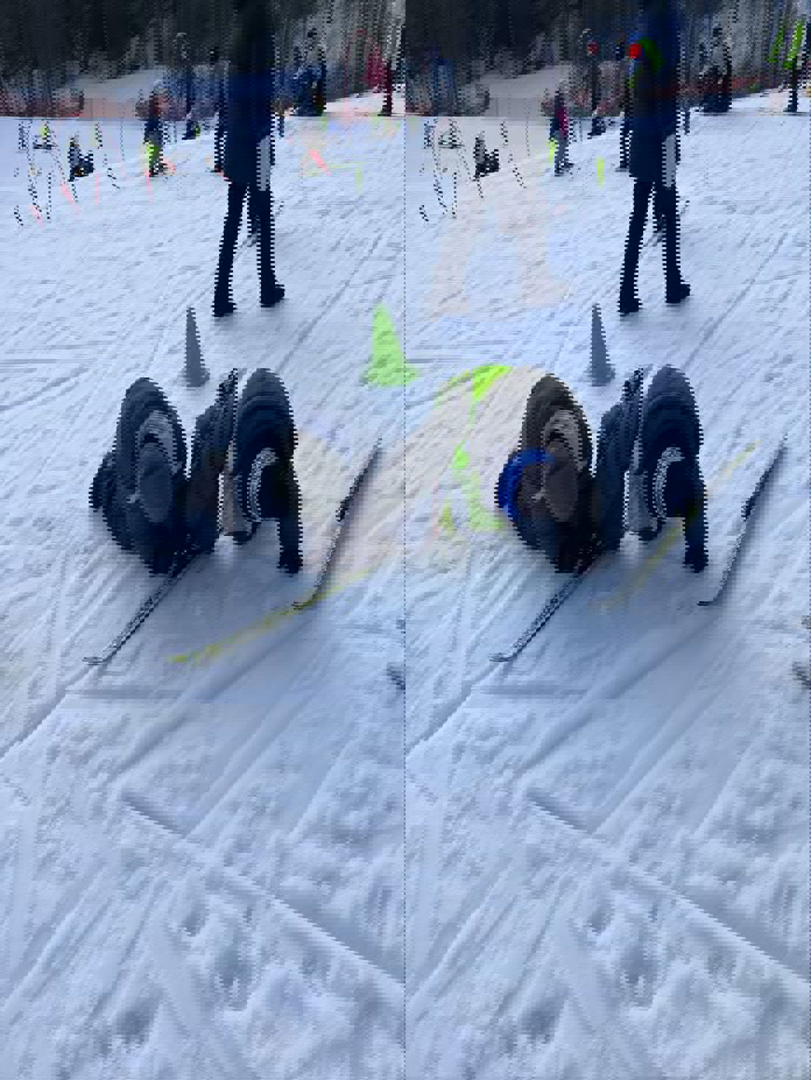 En person som ligger på snøen med ski på